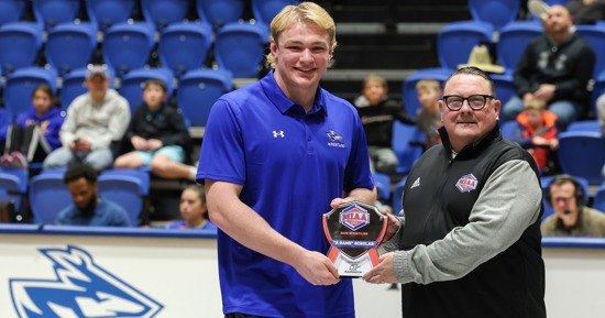 MIAA Commissioner Mike Racy, right, presents the “A Game” Scholar-Athlete award to UNK wrestler Crew Howard during a Feb. 14 dual at the Health and Sports Center. Howard has received the honor the past two years. (Photo by Erika Pritchard, UNK Communications)